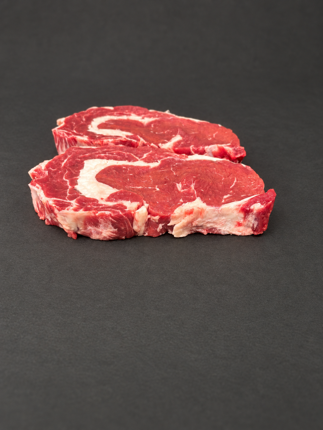 Ribeye Steak on a smooth charcoal background