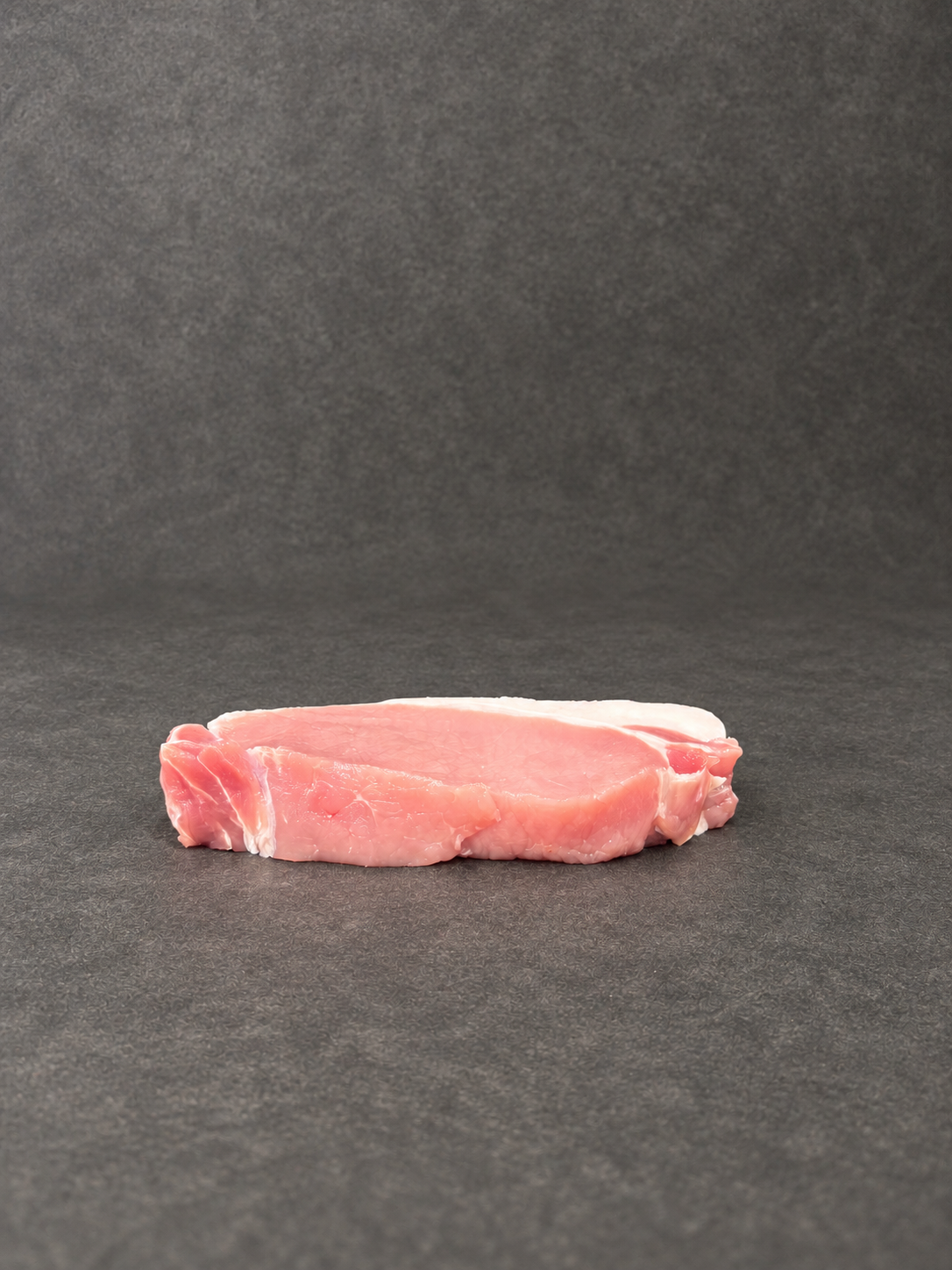 Pork Steaks on a smooth charcoal background