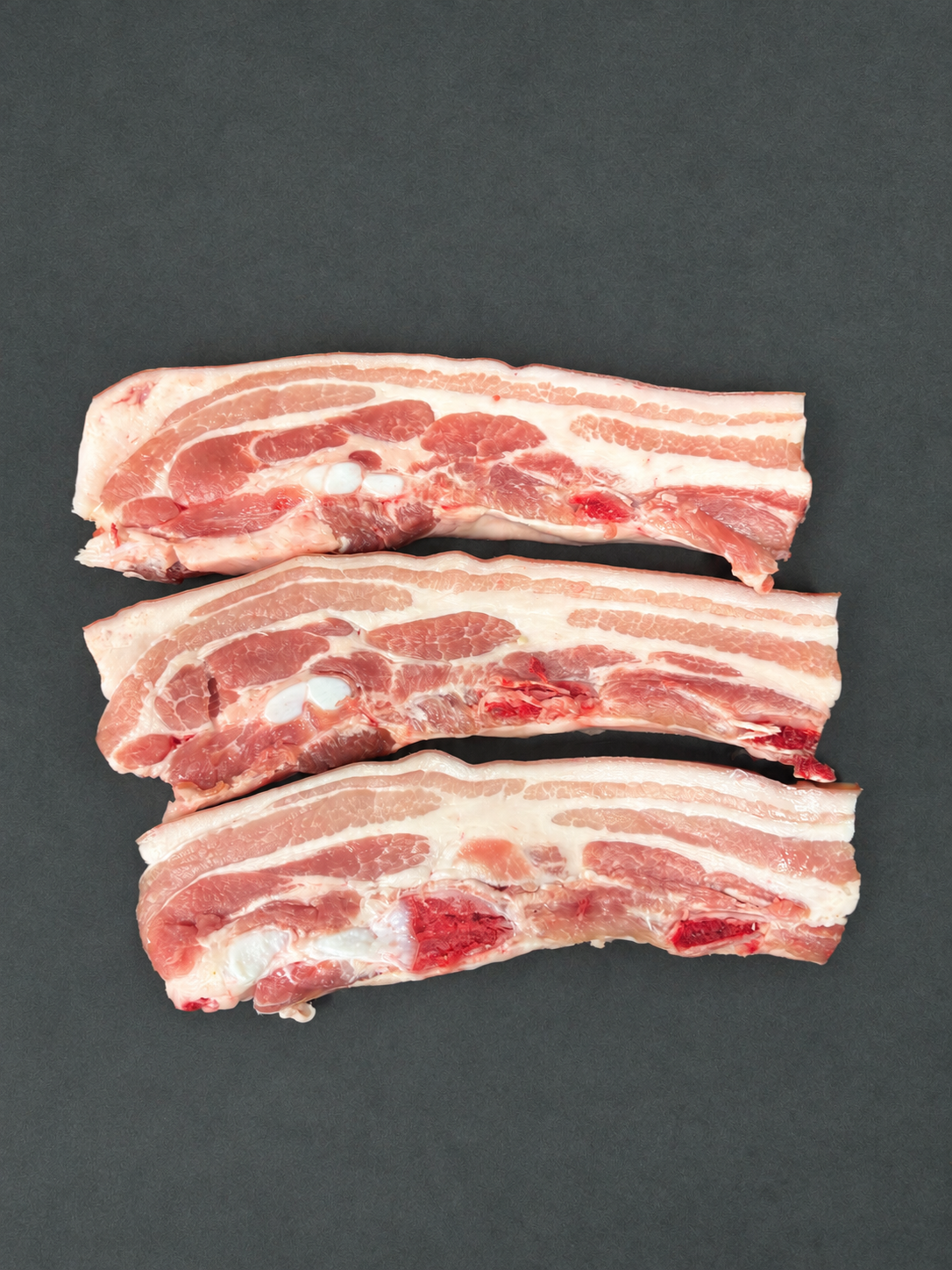 Pork Belly on a smooth charcoal background
