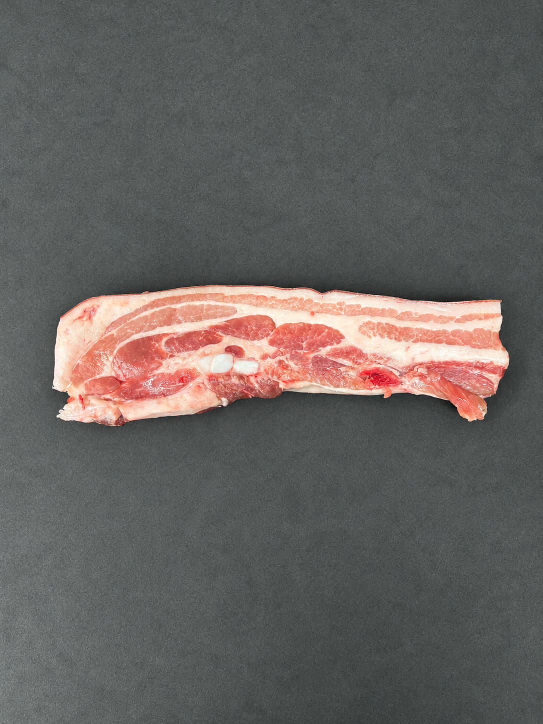 Pork Belly on a smooth charcoal background