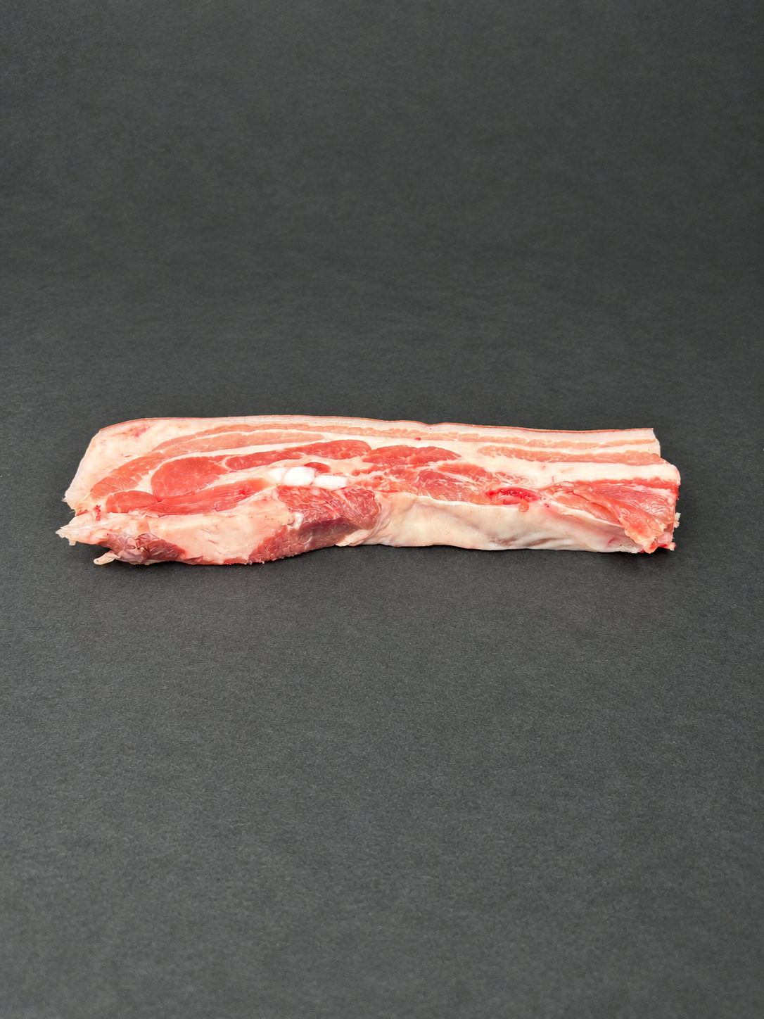 Pork Belly on a smooth charcoal background